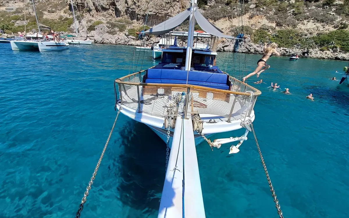 A private boat anchored off a quiet stretch of the Rhodes coast on a summer day